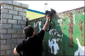 記者對廠內(nèi)情況進(jìn)行拍攝時(shí)，大門后伸出一把掃帚擋鏡。